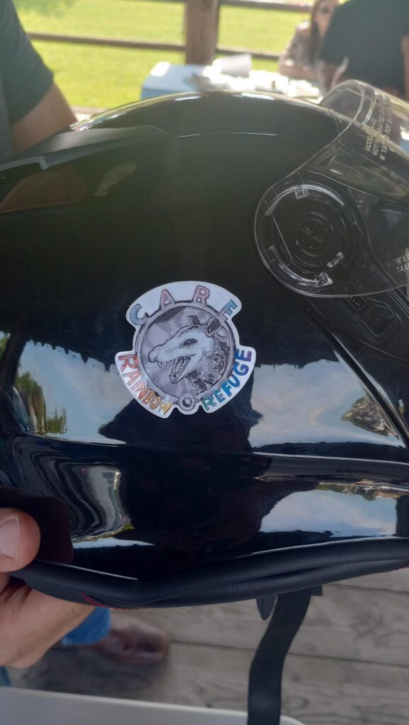 Rainbow Refuge sticker on a motorcyle helmet.